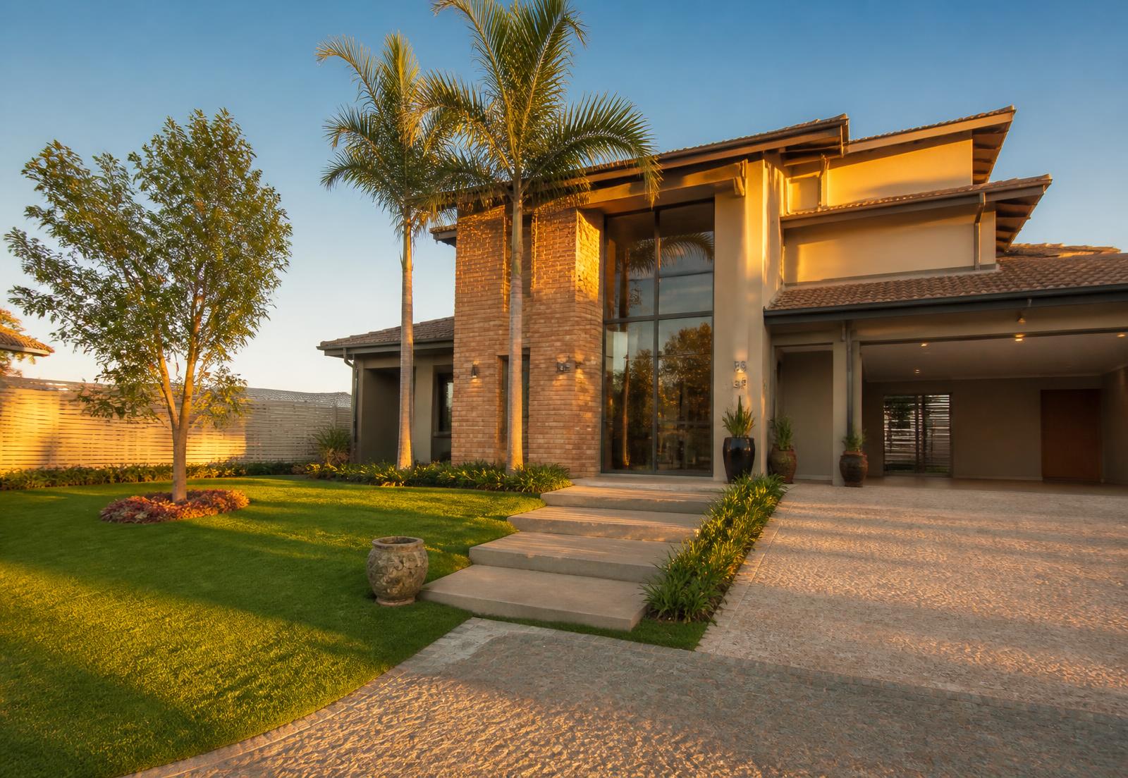 Casa moderna com jardim verde ao entardecer